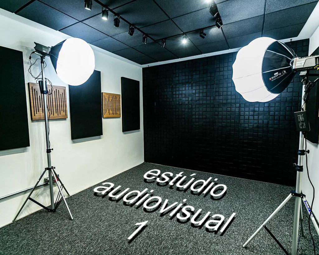 Estúdio audiovisual 1 da Capto com painéis acústicos, parede texturizada preta e softboxes de iluminação