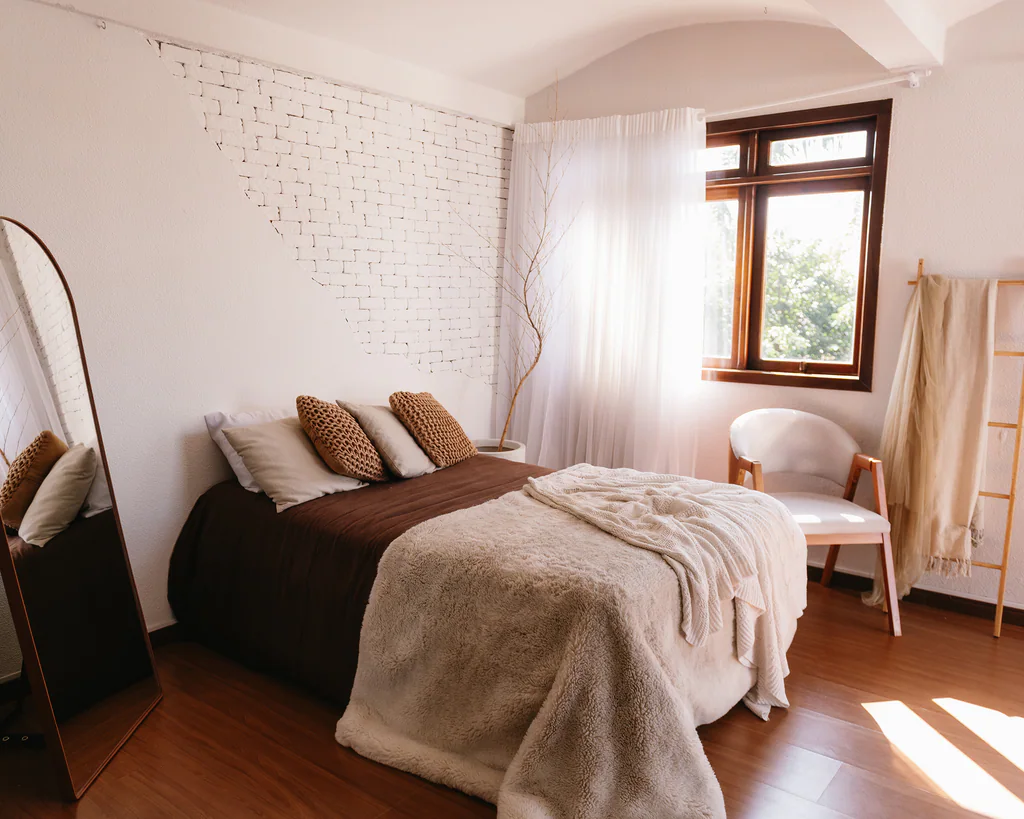Cenário de quarto com cama, espelho e janela com cortina no Studio Jardim Secreto