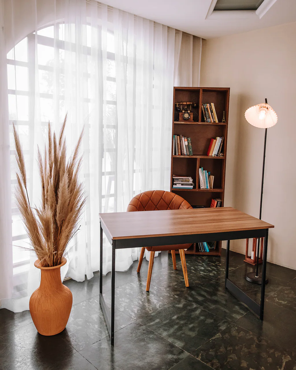 Mesa com cadeira, estante de livros e janela com cortina no Studio Keeper