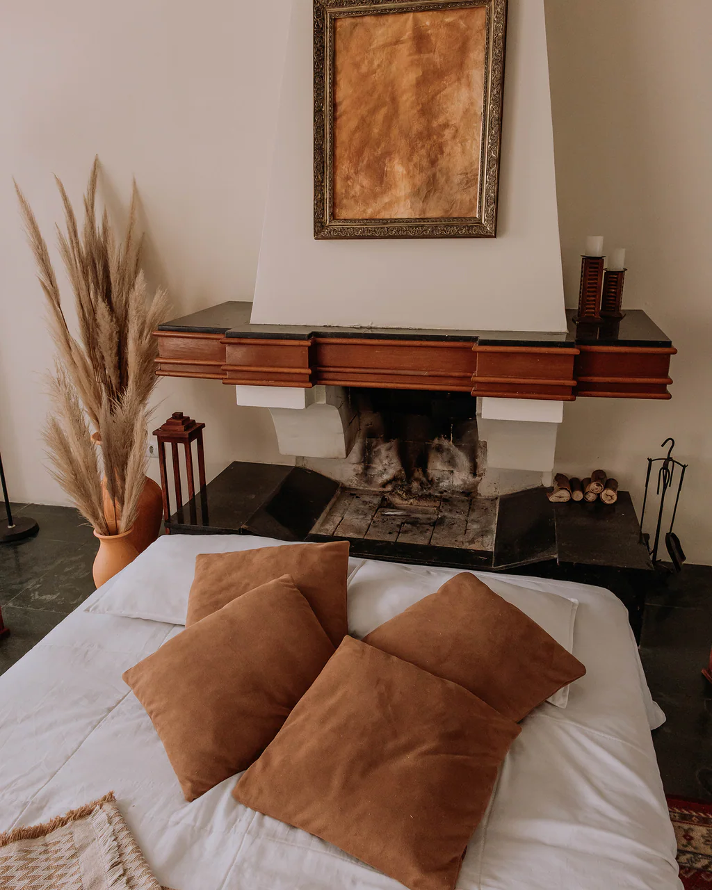 Lareira decorada com quadro, lanternas e arranjo de capim-dos-pampas no Studio Keeper